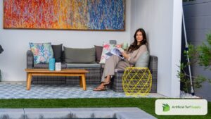 A woman smiling at her choice of fake grass for her patio