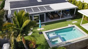 an aerial photo of a modern home witih a beautiful synthetic turf and pool in the backyard