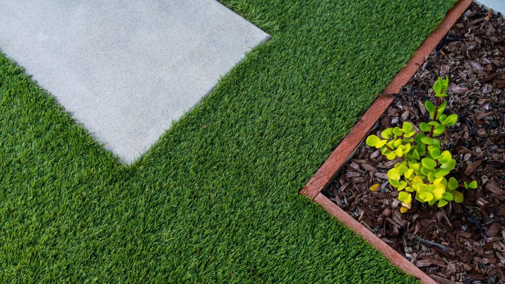 a closeup image of artificial turf as groundcover in a garden